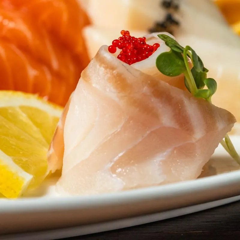Close up of fresh white fish sashimi with tobiko at Ichiban Alpharetta sushi bar